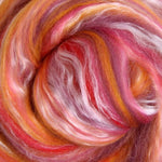 Close-up of shades of red, pink and orange fibre in a swirl pattern